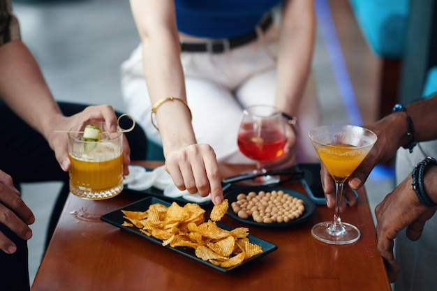 Foto pessoas a beber bebidas e aperitivos.