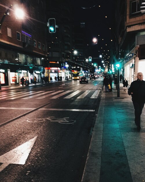 Foto pessoas a caminhar na estrada à noite.