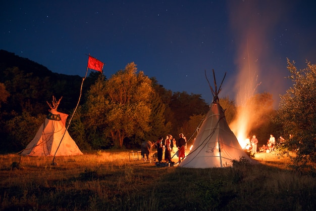 Pessoas acampando em uma floresta à noite