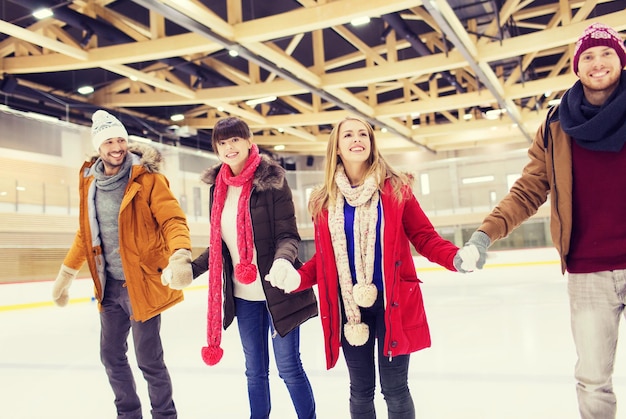 pessoas, amizade, esporte e conceito de lazer - amigos felizes na pista de patinação