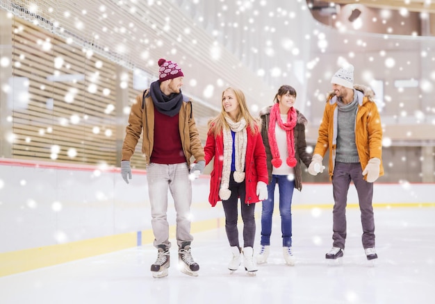 pessoas, amizade, esporte e conceito de lazer - amigos felizes na pista de patinação