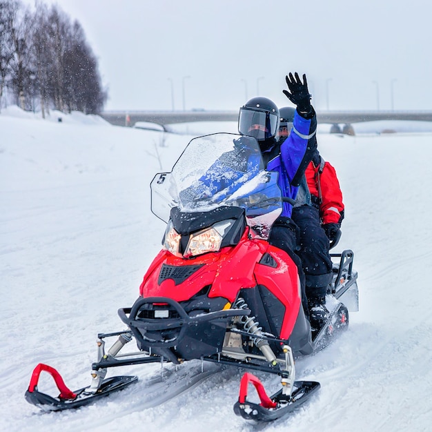 Pessoas andando de moto de neve no lago de neve congelada no inverno Rovaniemi, Lapônia, Finlândia