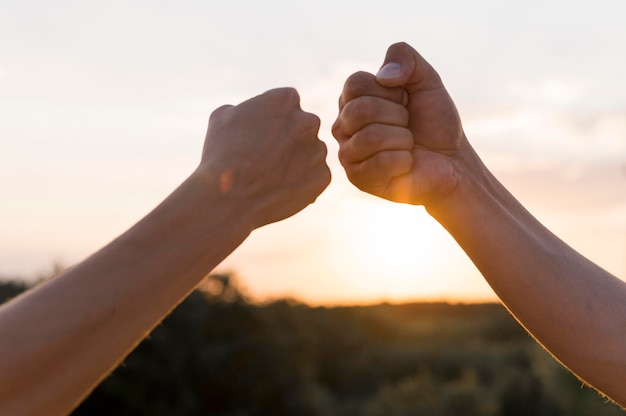 Foto pessoas batendo os punhos ao pôr do sol