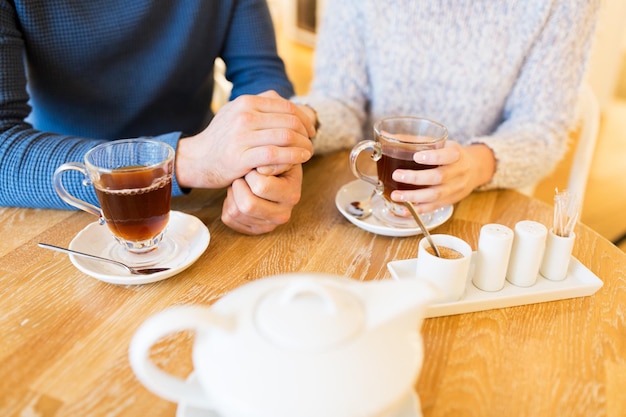 pessoas, bebidas e conceito de namoro - close-up de casal bebendo chá no café