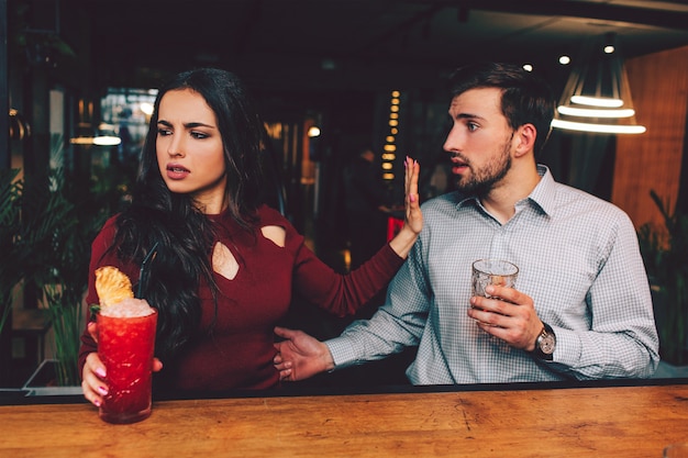 Foto pessoas bonitas sentadas muito próximas umas das outras na banca do barman