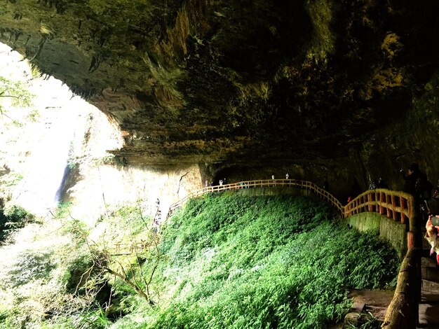 Foto pessoas caminhando na calçada pela caverna