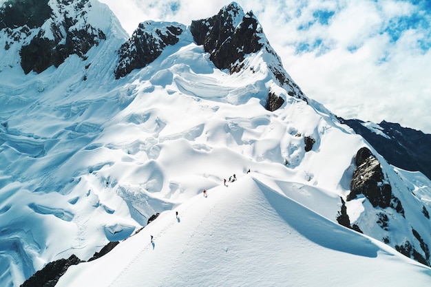 Pessoas caminhando na montanha coberta de neve contra o céu