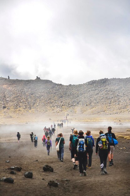 Pessoas caminhando na paisagem contra a cordilheira