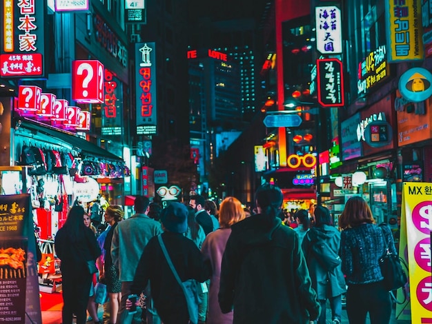 Pessoas caminhando no mercado na rua iluminada da cidade à noite