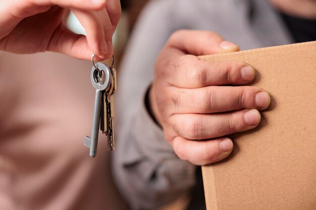 Pessoas casadas segurando as chaves da propriedade da casa para se mudarem e começarem novos começos juntos. Desfrutando de realocação e sendo proprietários, comprando o primeiro apartamento em empréstimo hipotecário. Fechar-se.