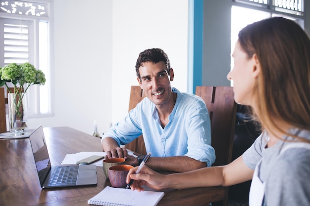 Pessoas casuais sentadas à mesa e discutindo o projeto