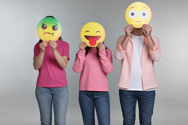 Foto pessoas cobrindo rostos com emoticons em fundo cinzento