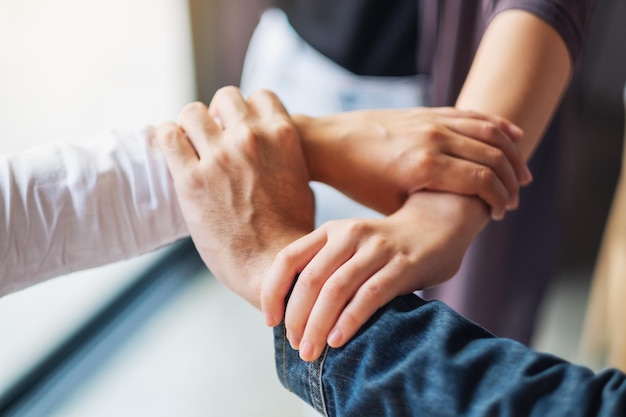 Pessoas colocando as mãos em um círculo juntas para o conceito de unidade e trabalho em equipe