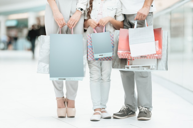 Pessoas com filha com sacos de compras estão em shopping center