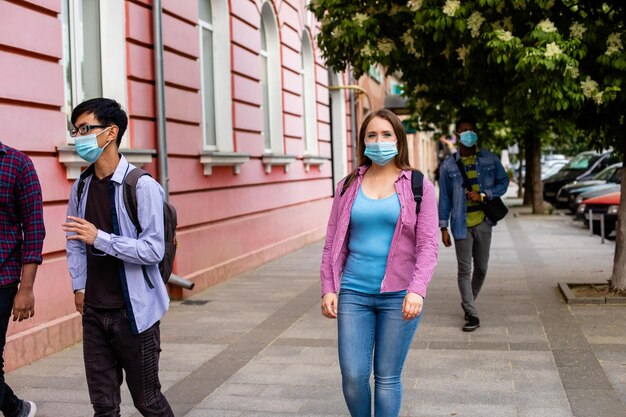 Pessoas com máscaras médicas andando na rua