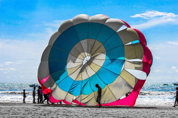 Foto pessoas com pára-quedas na praia contra o céu