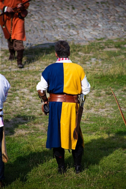 Pessoas com roupas medievais com laços no território do castelo ao ar livre
