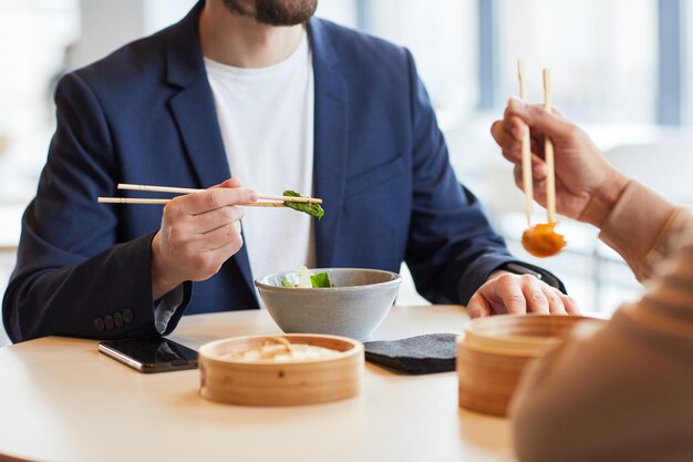 Pessoas comendo pratos de comida asiática