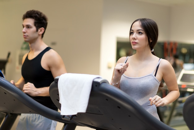 Pessoas correndo na esteira em uma academia