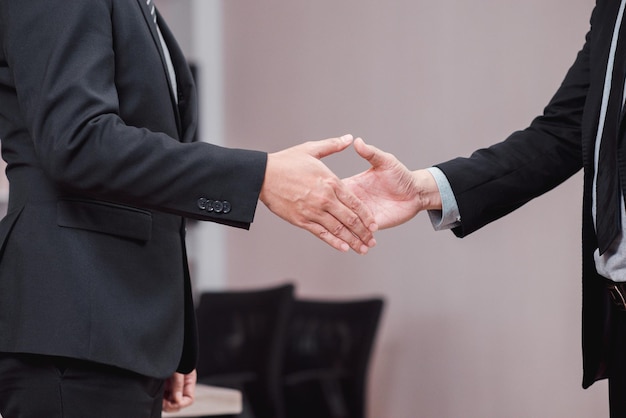 Pessoas da equipe de sucesso nos negócios apertando as mãos, terminando após uma reunião no escritório, trabalho em equipe bem-sucedido