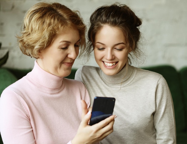 Pessoas da família e tecnologia Mulher idosa e sua filha adulta usando smartphone em casa