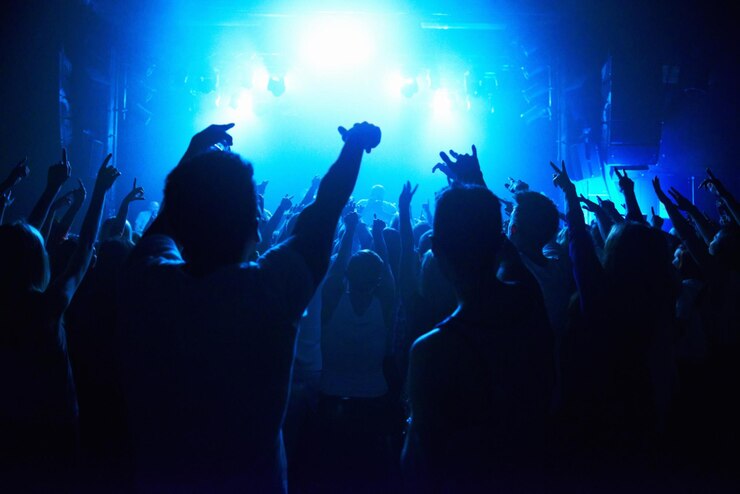 Foto pessoas de boate e multidão com energia e luzes para concerto de festa ou festival de rave com spotlight e dança disco evento psicodélico e performance com entretenimento público e vista traseira