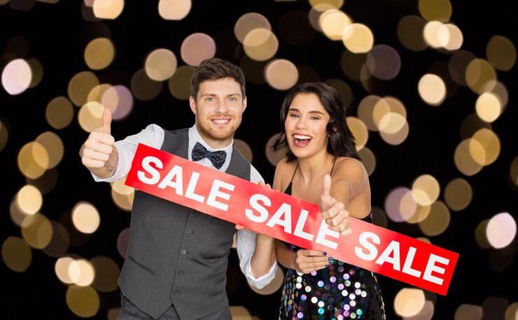 Foto pessoas de compras e conceito de moda casal feliz com sinal de venda vermelha mostrando polegares para cima sobre luzes em fundo preto