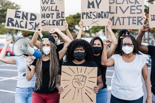 Pessoas de diferentes culturas e raças protestam nas ruas por direitos iguais durante o surto de coronavírus - Foco no rosto de mulher sênior