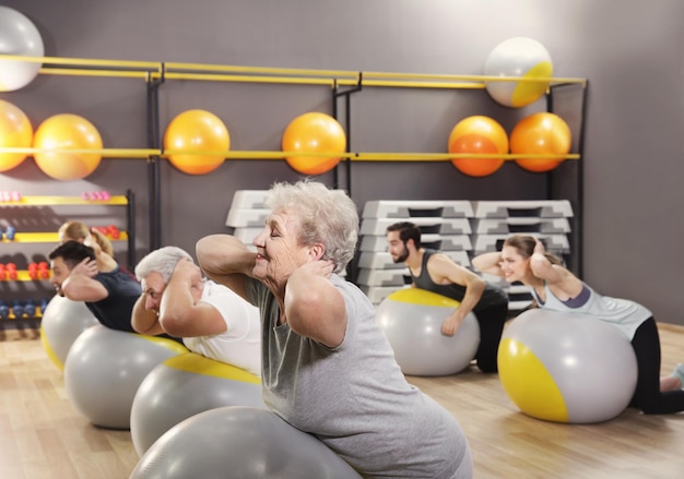 Foto pessoas de diferentes idades treinando com bolas no ginásio