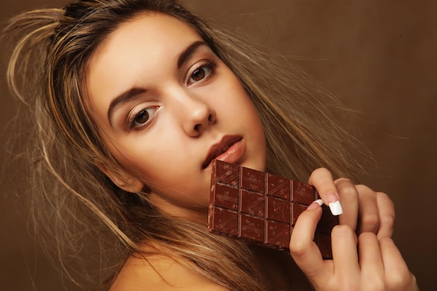 Pessoas de estilo de vida e conceito de comida Linda loira com chocolate em fundo bege