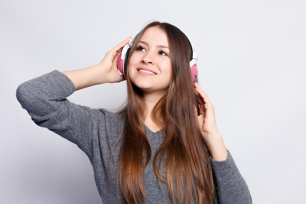 Foto pessoas de lazer e conceito de tecnologia mulher feliz ou adolescente em fones de ouvido ouvindo música do smartphone e dançando