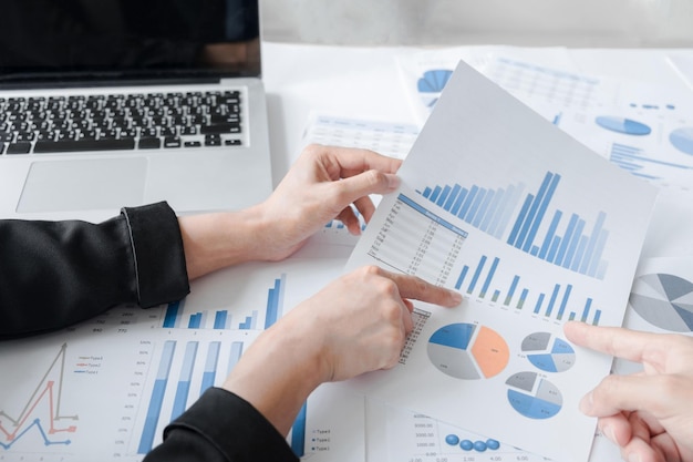 Pessoas de negócios a discutir sobre gráficos na secretária.