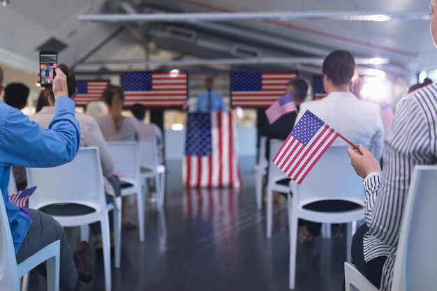 Foto pessoas de negócios agitando uma bandeira americana em um seminário de negócios