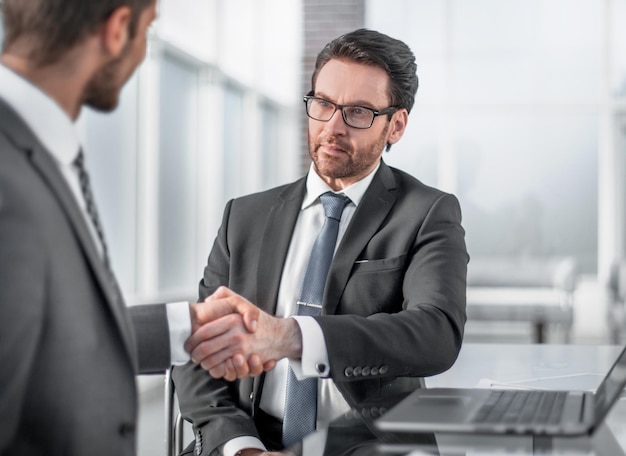 Pessoas de negócios apertando as mãos sobre uma mesa