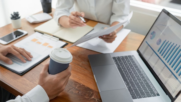 Pessoas de negócios conversando discutindo com o colega de trabalho, analisando tabelas e gráficos de dados de documentos financeiros