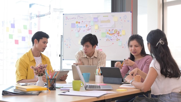 Pessoas de negócios de inicialização fazendo brainstorming e discutindo ideias para um novo projeto juntos no escritório moderno