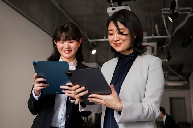 Foto pessoas de negócios de tiro médio trabalhando com ipad