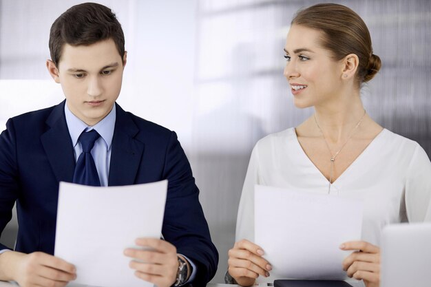 Pessoas de negócios discutindo algo enquanto estão sentados no escritório Foco na empresária enquanto conversa com seu colega masculino Trabalho em equipe e conceito de reunião