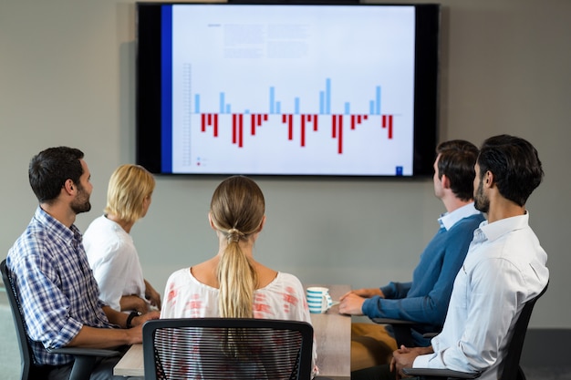 Pessoas de negócios, discutindo sobre o gráfico durante uma reunião