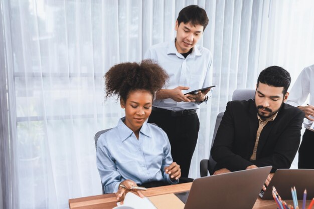 Foto pessoas de negócios diversas felizes trabalham juntas discutindo em escritórios corporativos trabalho em equipe profissional e de diversidade discutem o plano de negócios na mesa com o laptop trabalhador de escritório multicultural moderno concord