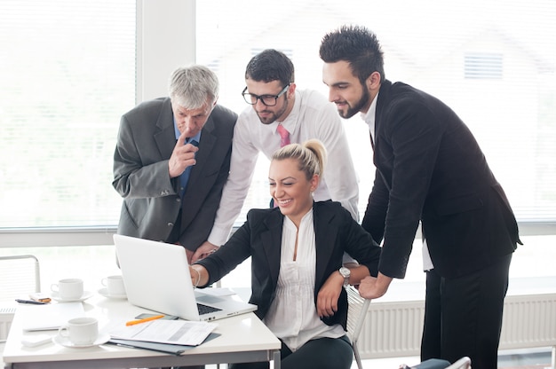 Pessoas de negócios e executivos tendo reunião usando laptop