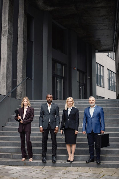 Pessoas de negócios em frente ao escritório moderno e posando para uma foto