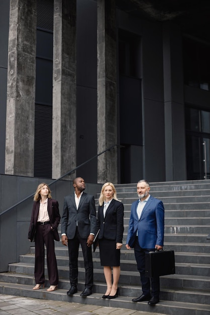 Pessoas de negócios em frente ao escritório moderno e posando para uma foto