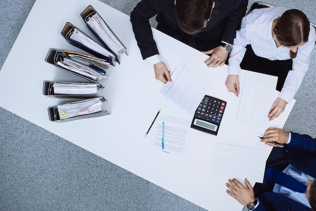 Pessoas de negócios em reunião, vista de cima. Guarda-livros ou inspetor financeiro fazendo relatório, calculando ou verificando saldo. Internal Revenue Service verificando documento financeiro. Auditoria e conceção fiscal