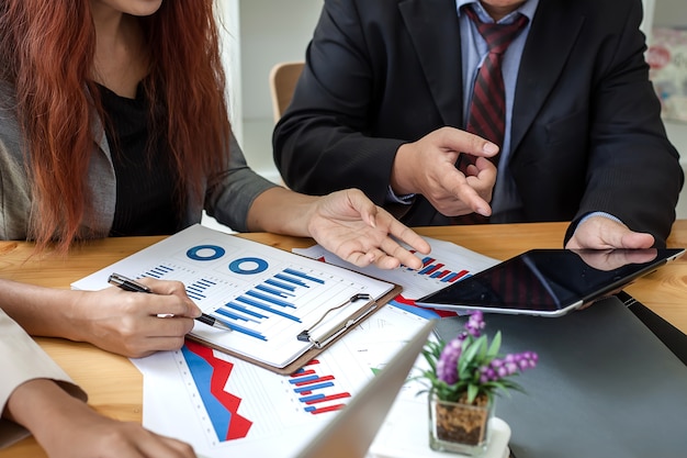 Pessoas de negócios em trabalhar com relatórios financeiros e um tablet.