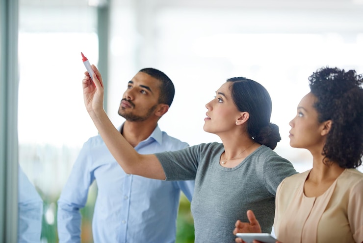 Foto pessoas de negócios escrevendo e planejando horários em tábuas de vidro para tarefas ou agenda no escritório grupo de jovens funcionários criativos tomando notas para discussão brainstorming ou startup no local de trabalho
