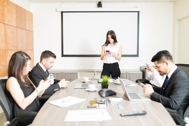 Pessoas de negócios multiétnicas mensagens em smartphones na sala de reuniões