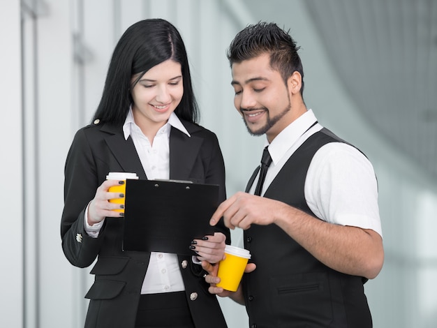 Pessoas de negócios permanente no escritório e beber café.