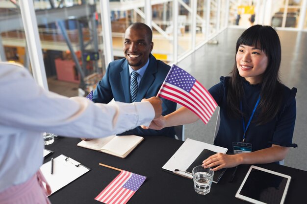 Foto pessoas de negócios segurando uma bandeira americana na mesa de registro da conferência