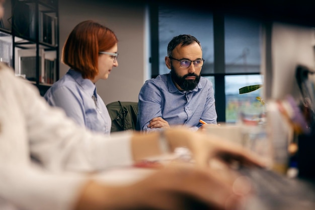 Pessoas de negócios sentadas no espaço de trabalho e discutindo